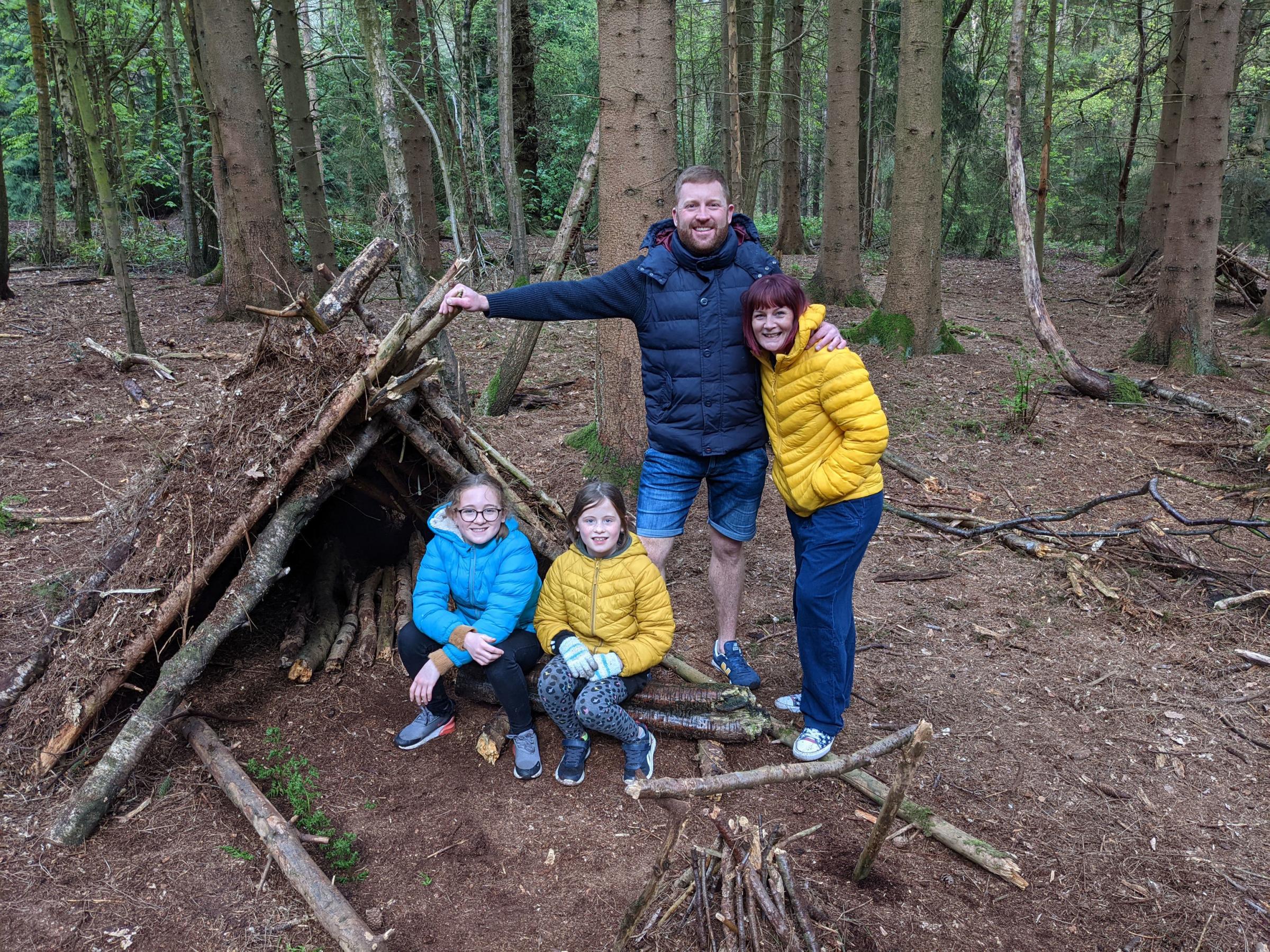 Claire Spreadbury and her family, outside the den they built in the forest. Photo: Claire Spreadbury/PA