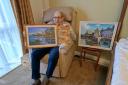 The care home's resident artist, Maurice, with some of his landscape pieces.