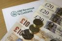 A HMRC (Her Majesty's Revenue and Customs) letter head surrounded by British bank notes and coins..