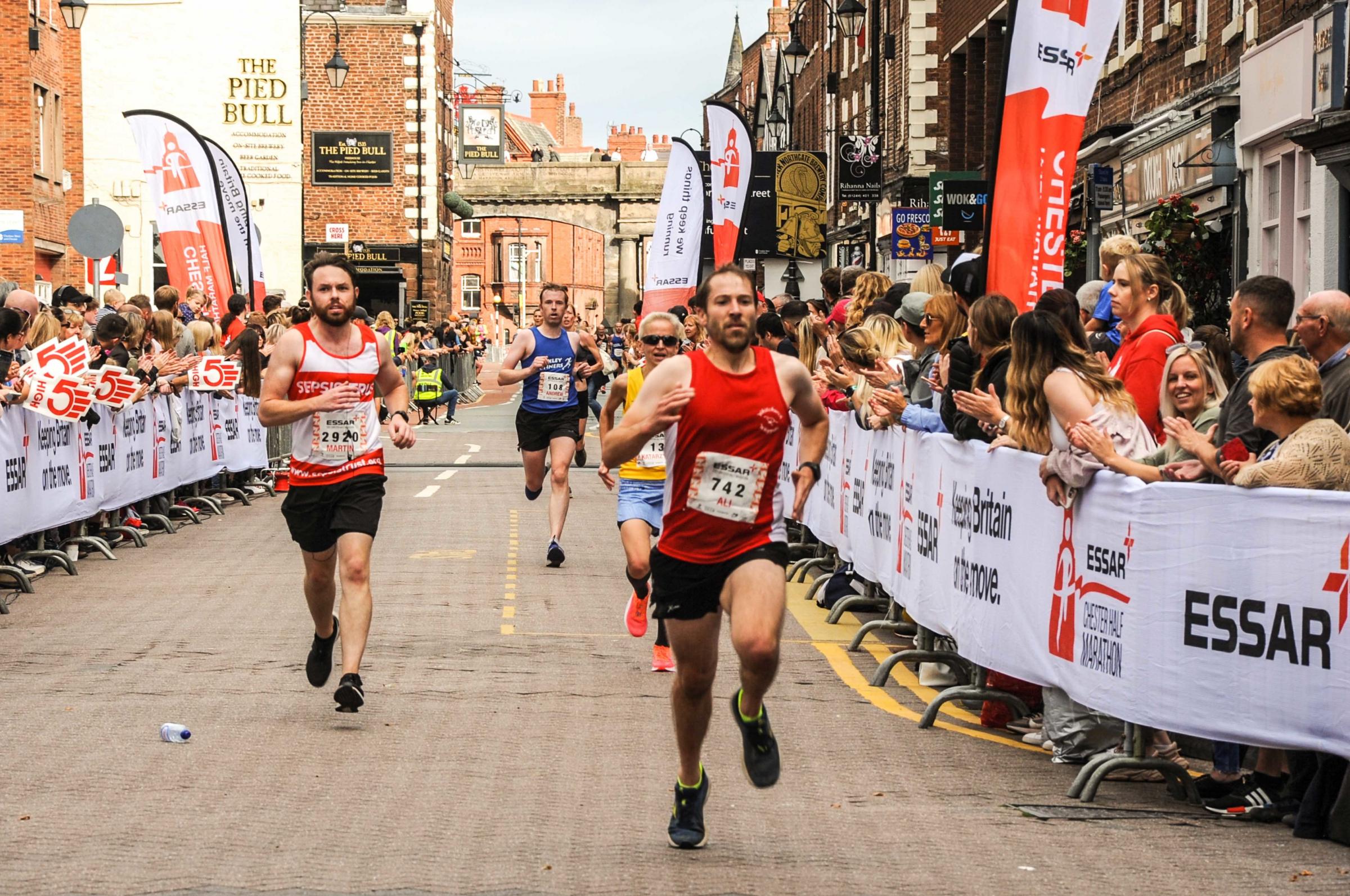 Chester Racecourse and Chester Town Hall, Essar 2021 Chester Half Marathon. Picture runners crossing the line. SW19092021.