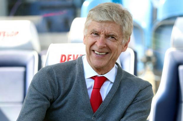 Arsene Wenger smiles in the dugout