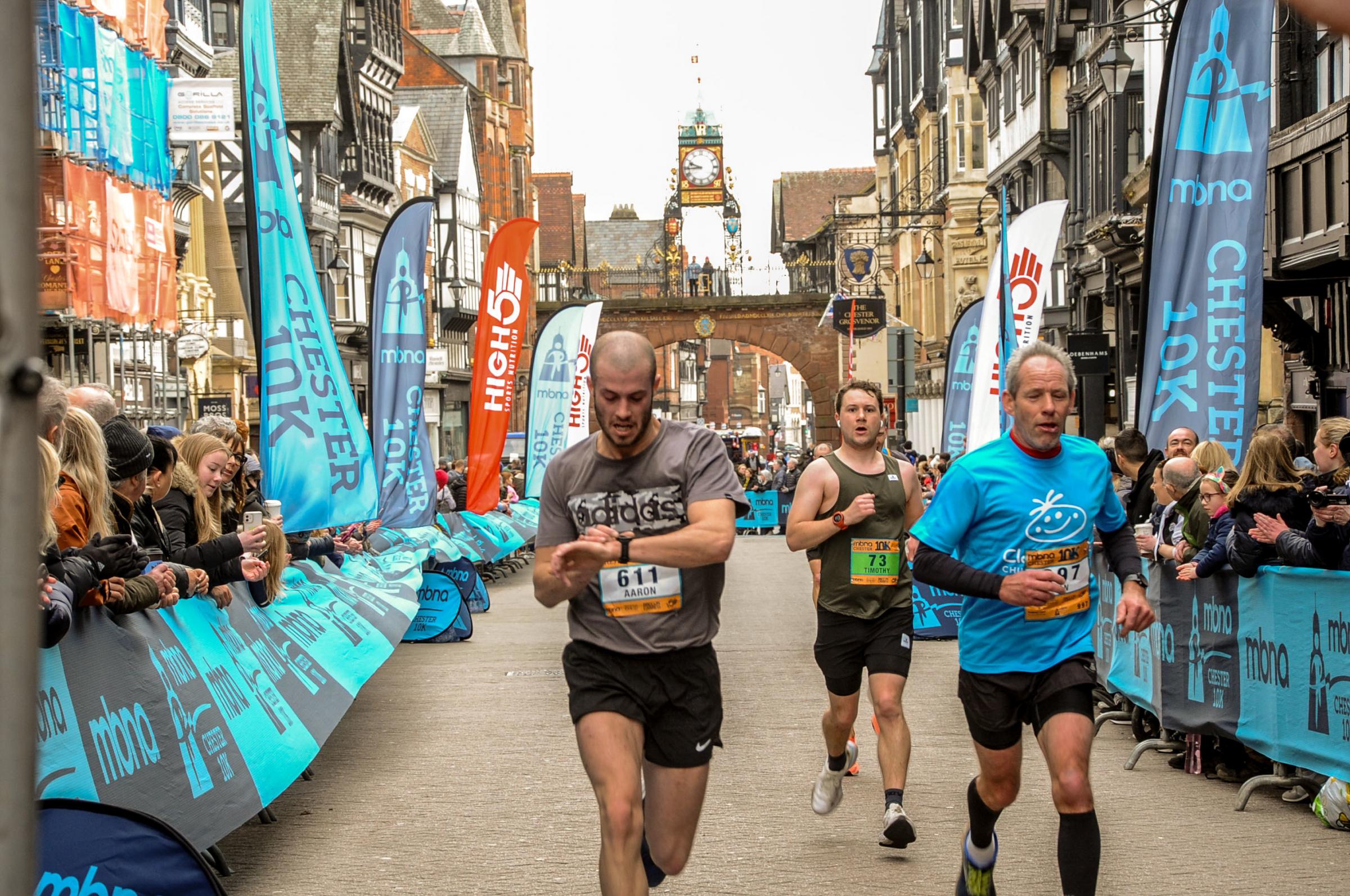 MBNA Chester 10K Race, Picture Runners crossing the finish line. SW13032022.