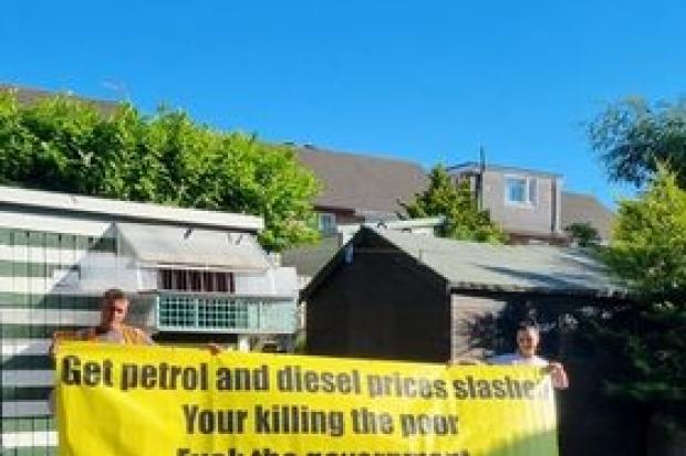 Daniel (left) and fiancee Becky with M53 bridge banner protest that urges: 'Get petrol and diesel prices slashed
