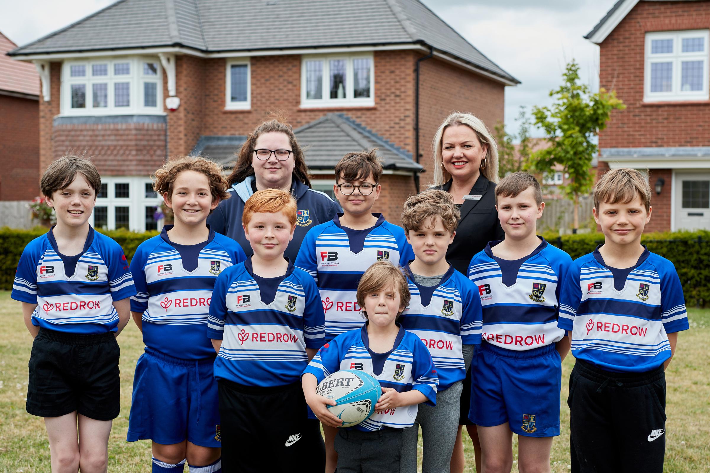 U11s coach Alex Webb and Redrow’s Kelly Chandler with members of Capenhurst Rugby team whose shirts have been sponsored by Redrow.