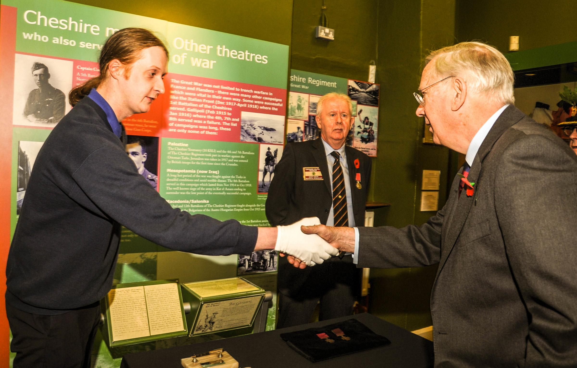 Museum staff Alex Clark greets HRH The Duke of Gloucester to view the pen used by US General MacArthur to sign the Japanese Instrument of Surrender, marking the end of hostilities in WWII.