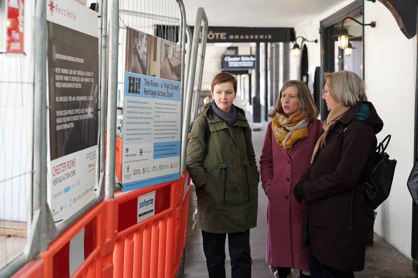 Pippa Brown (Historic Places Adviser, Historic England), Marie Smallwood (Head of Advice North, Historic England) and Samantha Dixon (MP, City of Chester) reading the interpretive boards that explain the work being done to improve the Chester Rows.