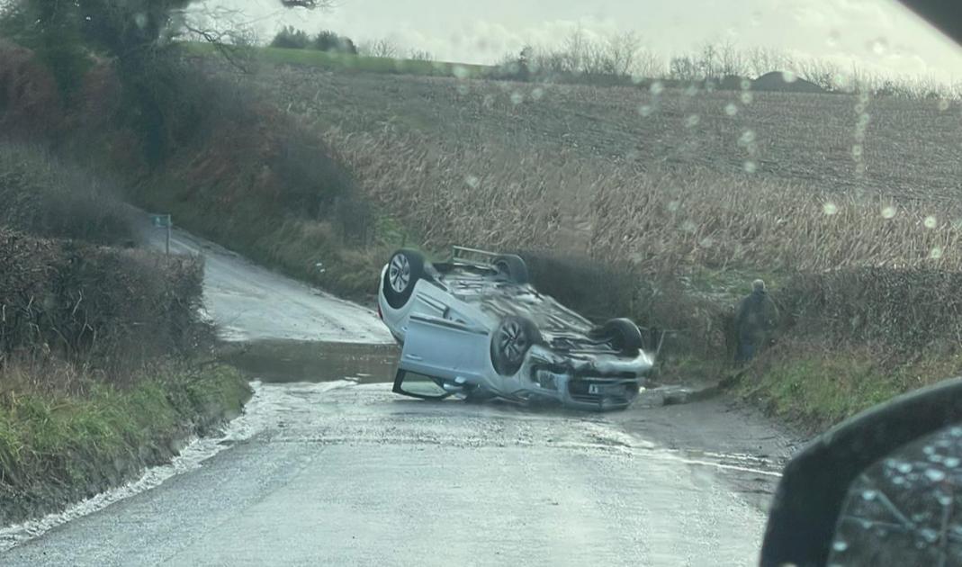 Car flips onto roof in crash on country lane 