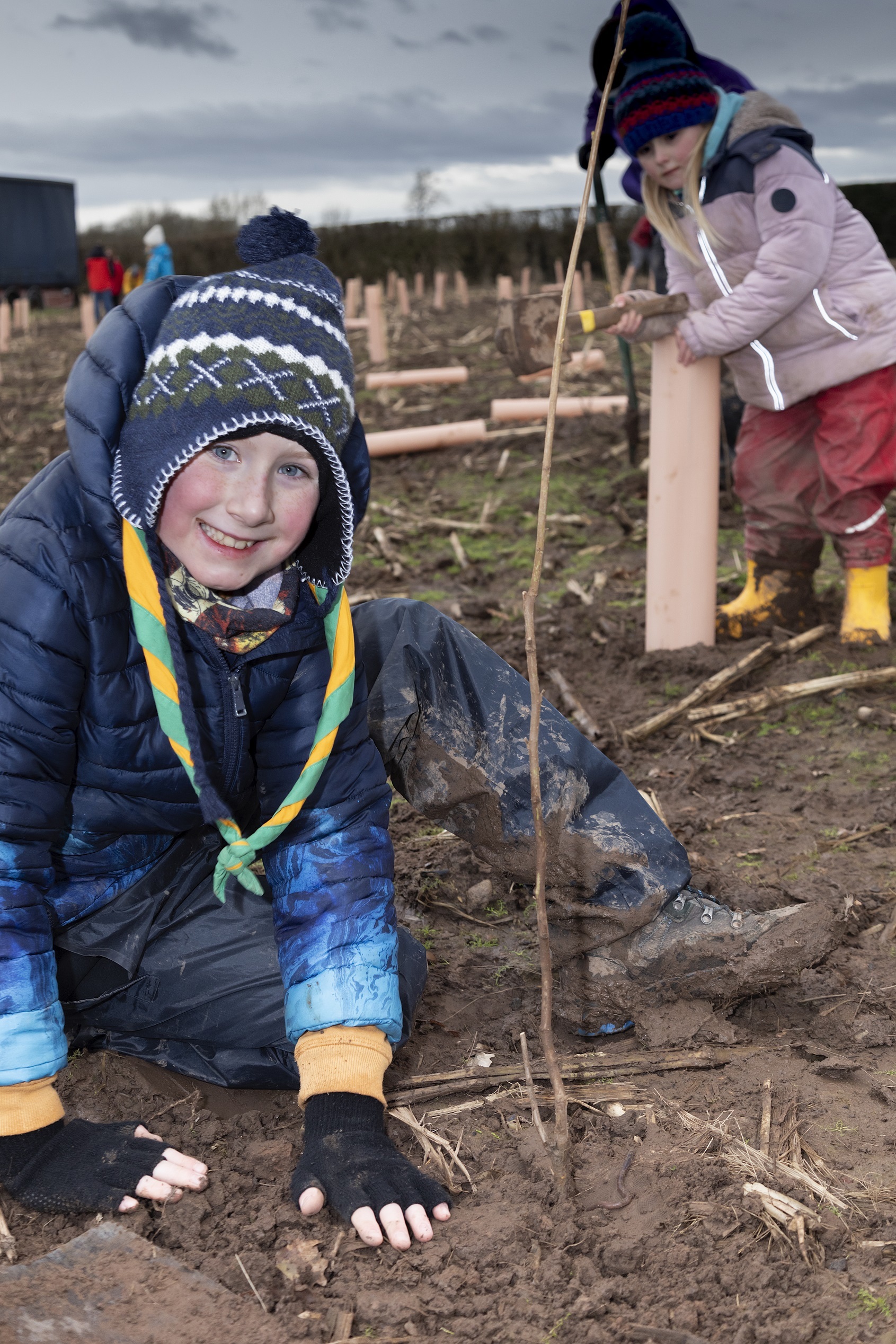 A young volunteer helping to plant one of the tree saplings.