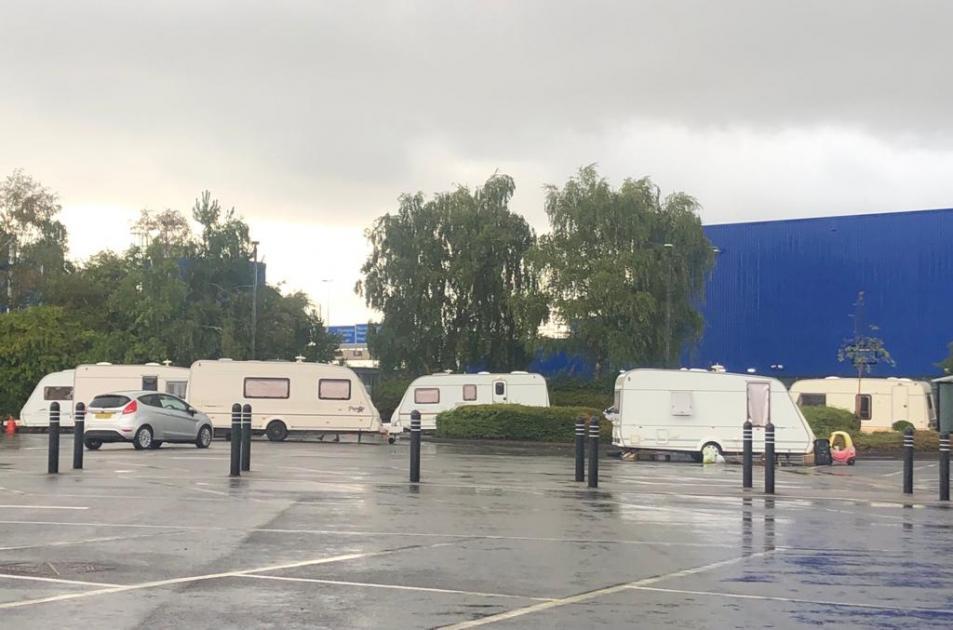 Traveller caravans set up camp on car park of Marks and Spencer 