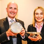 Tyrer Charitable Trustee Clive Pointon and Brittany Green of Aaron and Partners, holding a pair of early 18th century silver footed salvers, purchased by the Trustees of the Tyrer Charitable Trust.